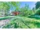 Lush backyard featuring a wooden deck, mature trees, and ample green space, ideal for outdoor activities and relaxation at 879 S Cole Dr, Lakewood, CO 80228