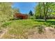 Sprawling backyard with mature trees, a patio and deck combination, and a lush lawn at 879 S Cole Dr, Lakewood, CO 80228