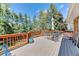 Back deck with outdoor seating and a view of the lush green yard and mature trees at 879 S Cole Dr, Lakewood, CO 80228