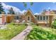Charming brick home with a manicured lawn and inviting front porch with chairs at 879 S Cole Dr, Lakewood, CO 80228