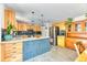 Spacious kitchen with granite countertops, blue tile island, and stainless steel appliances at 879 S Cole Dr, Lakewood, CO 80228