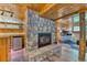 Cozy living room featuring a stone fireplace and rustic wood paneling at 879 S Cole Dr, Lakewood, CO 80228