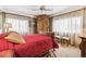 A bedroom showcases an antique armoire, a red comforter, and bright windows at 4000 Irving St, Denver, CO 80211