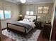 A neutral bedroom is furnished with dark wood furniture, soft linens, and shuttered windows at 4000 Irving St, Denver, CO 80211