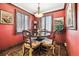 A cozy breakfast nook with red walls features a small round table and window shutters at 4000 Irving St, Denver, CO 80211