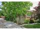 Charming brick home featuring mature landscaping, a lush green lawn, and a welcoming walkway at 4000 Irving St, Denver, CO 80211