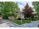 Charming brick home featuring a lawn and attractive landscaping. Real estate sign visible at 4000 Irving St, Denver, CO 80211