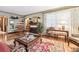 Cozy living room with fireplace, hardwood floors and natural light streaming in through curtains at 4000 Irving St, Denver, CO 80211
