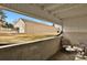 View of a spacious backyard with a detached garage, seen from a covered patio area with outdoor seating at 3872 S Fraser St # O03, Aurora, CO 80014