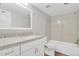 Bright bathroom featuring granite counters, white cabinets, framed mirror, and a shower-tub combo with stone-look surround at 3872 S Fraser St # O03, Aurora, CO 80014
