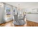 Bright dining area features hardwood floors, a chandelier, large windows, custom window treatments, and backyard views at 858 S Emerson St, Denver, CO 80209