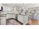 Bright kitchen boasts white cabinets, a granite countertop island, stainless steel appliances, and hardwood floors at 858 S Emerson St, Denver, CO 80209