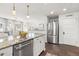 Bright kitchen features stainless steel appliances, a large island with granite countertops, and modern pendant lighting at 858 S Emerson St, Denver, CO 80209