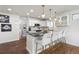 Open kitchen features a bar with seating, granite countertops, white cabinets, tile flooring, and pendant lighting at 858 S Emerson St, Denver, CO 80209