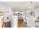 Open floor plan showcases kitchen with bar seating, hardwood floors, and is adjacent to dining area with a chandelier at 858 S Emerson St, Denver, CO 80209