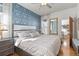Bright main bedroom with large bed, patterned wallpaper, hardwood floors and doorway to sunroom at 858 S Emerson St, Denver, CO 80209