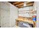 Unfinished basement area with workspace, pegboard, and shelving at 12690 W Brandt Dr, Littleton, CO 80127