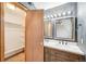 Bathroom with a large wood vanity with dual sinks and framed mirrors and a walk in closet at 12690 W Brandt Dr, Littleton, CO 80127
