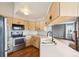 Spacious kitchen featuring stainless steel appliances, light-colored wood cabinets, and white countertops at 12690 W Brandt Dr, Littleton, CO 80127