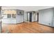 Open-concept living area with hardwood floors, a view of a shelf with plant, and a hall to a bathroom at 12690 W Brandt Dr, Littleton, CO 80127