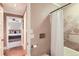 Clean bathroom featuring neutral tile and a tub with shower, bedroom visible in distance at 275 Pearl St # 11, Boulder, CO 80302