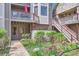 Charming condo exterior with colorful flowers, gray siding, and red trim accents on the staircase and second story balcony at 275 Pearl St # 11, Boulder, CO 80302
