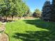 This spacious backyard has manicured landscaping with mature trees and lush green grass at 4074 S Poplar Way, Denver, CO 80237