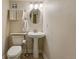Cozy powder room featuring a pedestal sink, oval mirror, and neutral decor at 4074 S Poplar Way, Denver, CO 80237