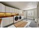 Functional laundry room with modern appliances, built-in cabinets, and ample counter space for efficient chores at 4074 S Poplar Way, Denver, CO 80237