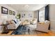 Sunlit living room featuring a neutral color palette, stylish rug, and comfortable seating arrangement at 4074 S Poplar Way, Denver, CO 80237