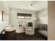 Cute Bedroom with wallpaper, a crib, a comfortable chair, and playful decor at 2060 Kline St, Lakewood, CO 80215