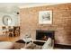 Cozy living room showcasing a brick fireplace with a view into the dining room at 2060 Kline St, Lakewood, CO 80215