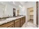 Bathroom featuring dual sinks, large mirror, and a walk-in closet for ample storage space at 12993 E 108Th Ave, Commerce City, CO 80022