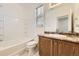 Bright bathroom featuring a tub/shower combo, a single sink vanity, and a window for natural light at 12993 E 108Th Ave, Commerce City, CO 80022