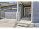 A charming home exterior featuring blue siding and a gray door with a 2-car gray garage at 12993 E 108Th Ave, Commerce City, CO 80022