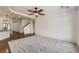 Bright living room featuring plush carpet, ceiling fan, and a view leading into the kitchen at 12993 E 108Th Ave, Commerce City, CO 80022