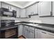 A kitchen featuring black appliances, gray cabinets and dark countertops at 1020 15Th St # 28G, Denver, CO 80202