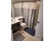 Neutral bathroom with a single sink vanity, patterned flooring, and shower-tub combo at 15507 E Louisiana Ave, Aurora, CO 80017