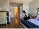 Spacious bedroom featuring wood floors, exercise bike, and access to a hallway at 15507 E Louisiana Ave, Aurora, CO 80017