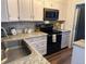Modern kitchen featuring stainless steel appliances, white cabinetry, and sleek countertops at 15507 E Louisiana Ave, Aurora, CO 80017