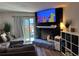 Cozy living room with a stone fireplace and sliding glass doors to the backyard at 15507 E Louisiana Ave, Aurora, CO 80017