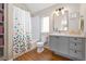 Bathroom featuring a tub, white subway tiles, wooden floors, and a gray vanity with a white countertop at 1691 W 66Th Ave, Denver, CO 80221