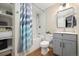Bright bathroom featuring tub with modern tile, sleek vanity, and storage shelves at 1691 W 66Th Ave, Denver, CO 80221