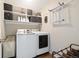 Well-equipped laundry room featuring modern appliances, upper cabinets, and a hanging rack for clothes at 1691 W 66Th Ave, Denver, CO 80221