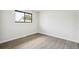 Empty bedroom with dark framed window, plank flooring, and white baseboards at 2767 W Iliff Ave # 1, Denver, CO 80219