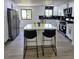 Modern kitchen featuring white cabinets, a black backsplash, and a spacious island with bar stools at 2767 W Iliff Ave # 1, Denver, CO 80219