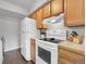 Well-maintained kitchen with white appliances, wooden cabinets, and laminate countertops at 7318 S Xenia Cir # B, Centennial, CO 80112