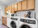 A well lit laundry area features stainless appliances and sleek wooden cabinets at 7318 S Xenia Cir # B, Centennial, CO 80112