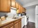 Laundry area with wood cabinets, stainless steel sink, and modern appliances at 7318 S Xenia Cir # B, Centennial, CO 80112