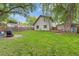 Spacious backyard with a lush lawn, mature trees, patio area, shed, and wooden fence at 32 Powder Horn Pl, Longmont, CO 80504